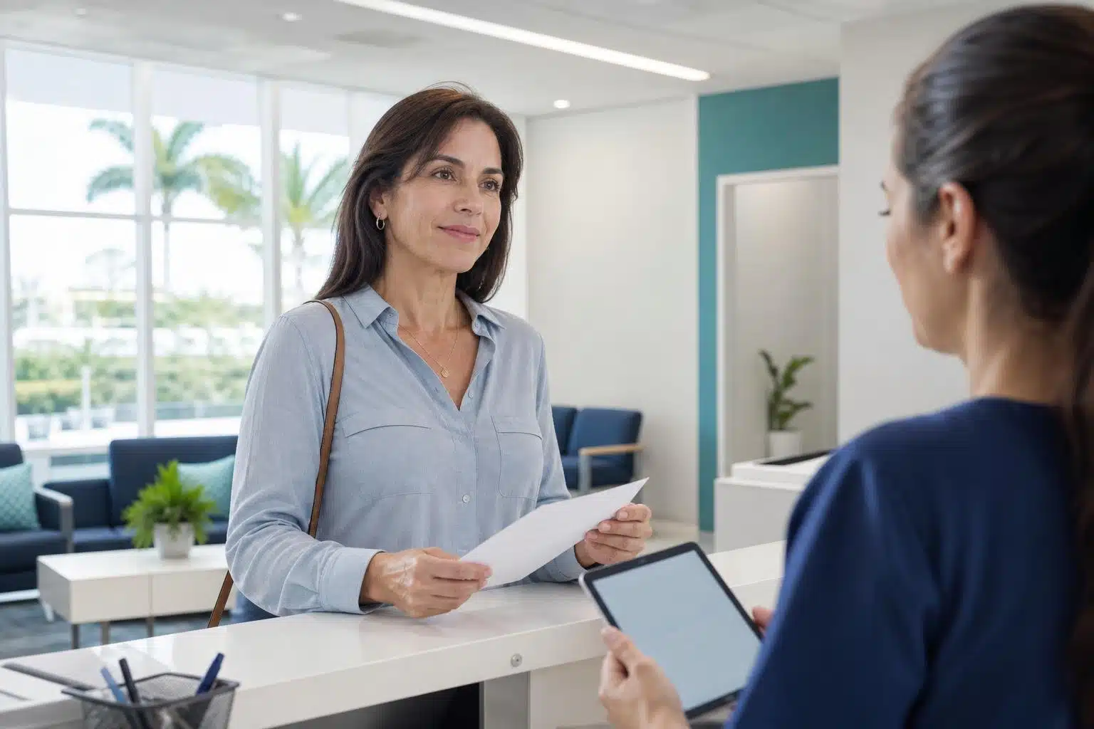Paciente conversa com atendente sobre um pedido de exames na recepção de um laboratório.